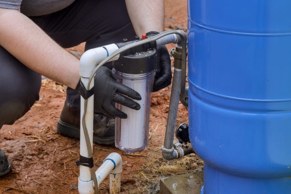 An installation of water purification filter cartridge is being performed by maintenance service technician